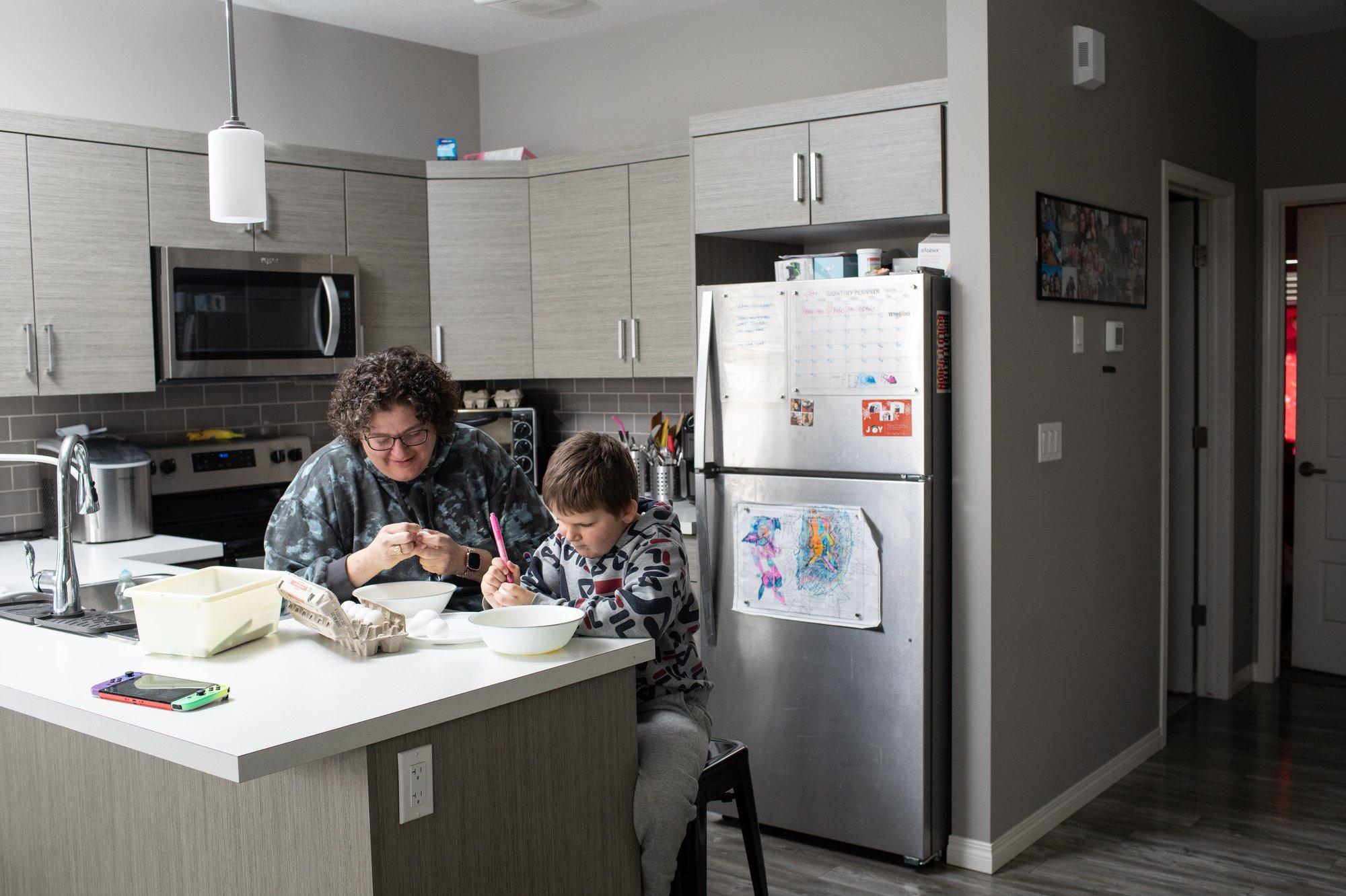 Odette and Cody decorate easter eggs together in their Lacombe home