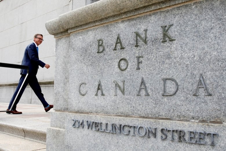 A man walks into the Bank of Canada building.