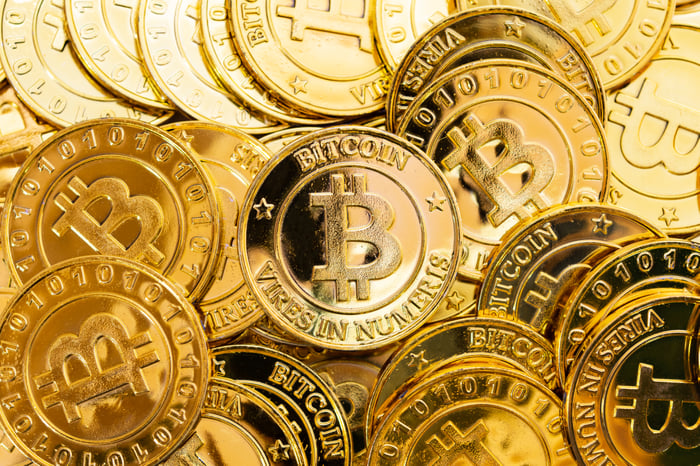 A pile of gold coins with the Bitcoin logo.