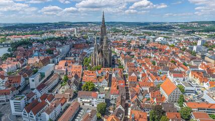 Blick von oben auf eine Großstadt mit riesiger Kirche in der Mitte.