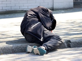 A man lies on the sidewalk in Vancouver's Downtown Eastside on April 18, 2024.