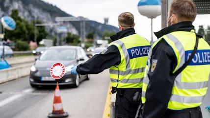 Deutsche Bundespolizisten kontrollieren an der Grenze zu Österreich auf der Autobahn A93 den Verkehr.