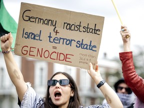 A woman holds a placard as people protest outside the International Court of Justice.