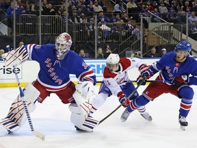 Canadiens player tries to stuff the puck past Rangers goalie