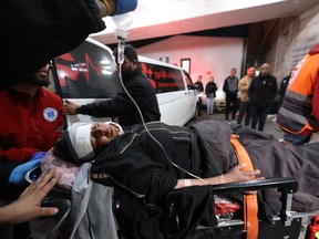 A wounded Palestinian man arrives for treatment for injuries sustained in clashes with Israeli settlers in the village of Mughayir, at a hospital in Ramallah in the occupied West Bank on April 12, 2024.