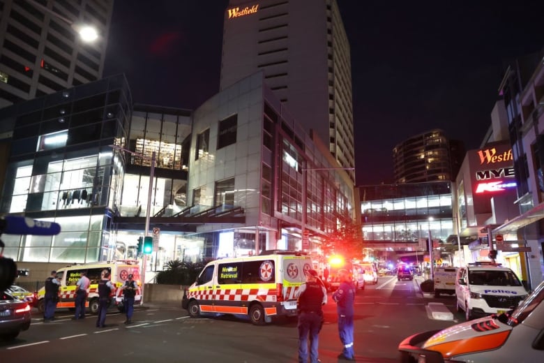 Police and ambulances block roads leading to a shopping centre.