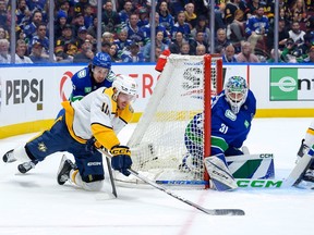 Quinn Hughes and Arturs Silovs of the Vancouver Canucks defend against Colton Sissons of the Nashville Predators during the second period in Game 5 of the First Round of the 2024 Stanley Cup Playoffs at Rogers Arena on Tuesday night. The Predators won 2-1.