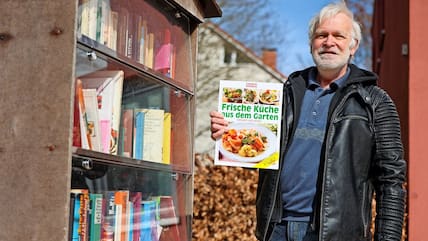 Michael Groth (65) ist im Bücherschrank am Hansering fündig geworden: Er hat einen Kleingarten und kocht – das perfekte Buch für ihn. 