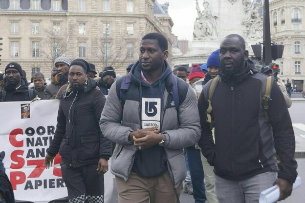 Protestierende mit Transparenten laufen durch Paris.