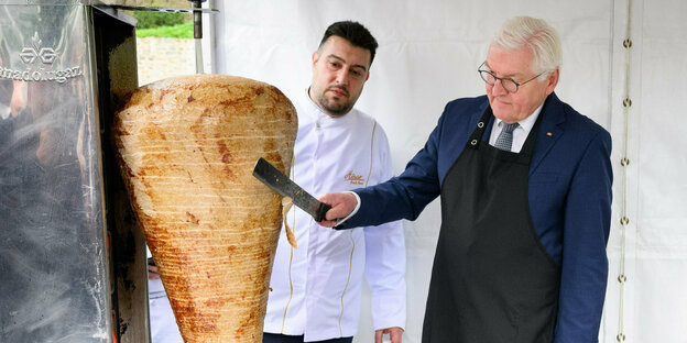 Bundespräsident Steinmeier steht vor einem Dönerspieß und schneidet ihn