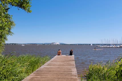 Ein Paar sitzt auf einem Steg am Steinhuder Meer.