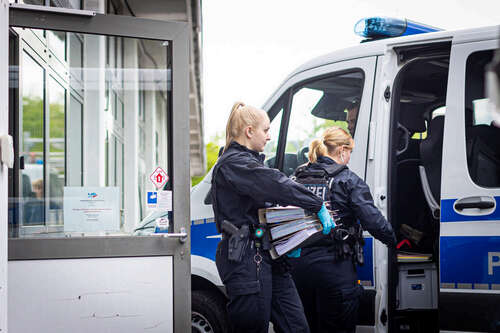 Polizeibeamtinnen gehen während einer Durchsuchung mit Ordnern an einem Polizeiwagen vorbei. Der niedersächsische Landtag hatte die Immunität von zwei Abgeordneten aufgehoben. In der Folge durchsuchten Ermittler am Mittwochmorgen die Geschäftsräume des niedersächsischen Landesverbandes sowie eines Kreisverbandes der AfD in Hannover. Dabei geht es nach Angaben der Staatsanwaltschaft um den Anfangsverdacht eines Verstoßes gegen das Parteiengesetz gegen einen AfD-Landtagsabgeordneten.