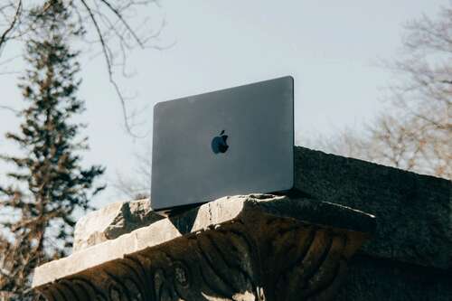 MacBook sitting on a ledge. 
