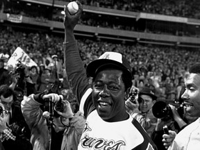 Hank Aaron holds aloft the ball he hit for his 715th career home run.