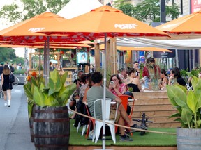 People enjoy drinks on a terrasse on Mount Royal Ave. in Montreal