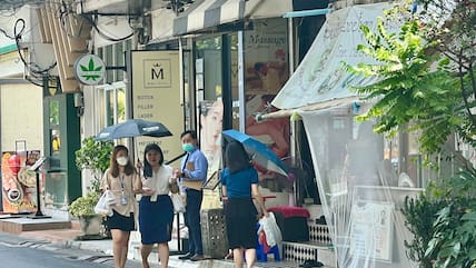 Frauen schützen sich mit Schirmen vor der extremen Hitze in Bangkok. Weite Teile Thailands stöhnen derzeit unter einer extremen Hitzewelle.