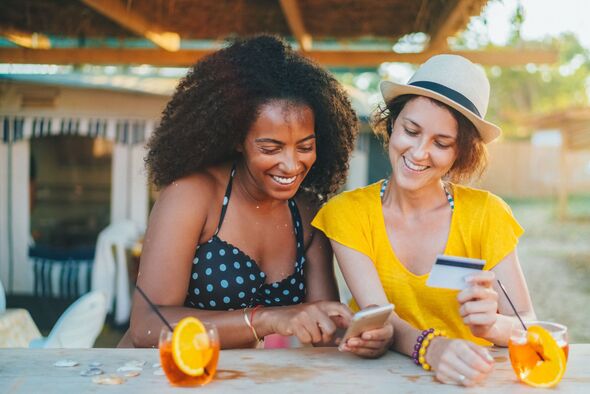 Friends smiling while online banking