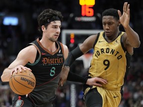 Washington Wizards forward Deni Avdija moves the ball up court as Toronto Raptors guard RJ Barrett defends.