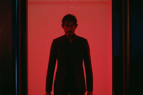 Dev Patel stands in an elevator in Monkey Man.