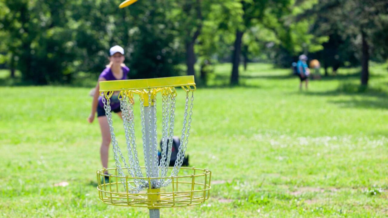 Young woman playing flying disc sport game in the park