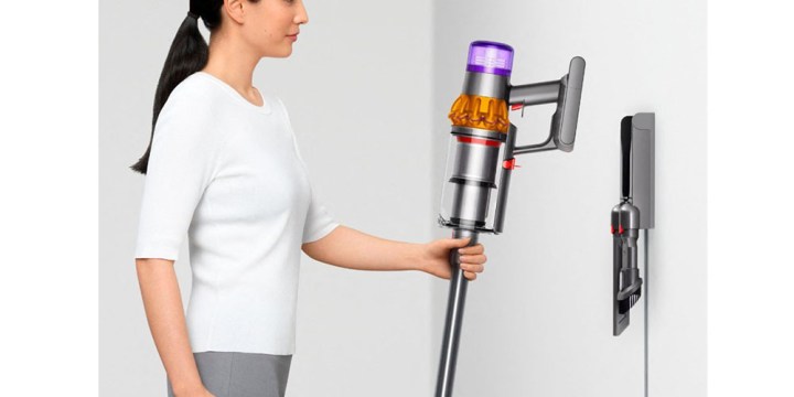 A woman placing the Dyson V15 Detect in its dock.