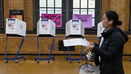 Eine Wählerin aus New York geht am Dienstag an Wahlkabinen vorbei.