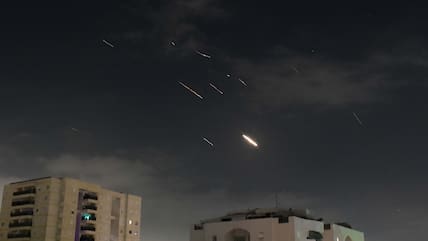 Flammen von Explosionen erscheinen am Himmel über Tel Aviv, während Israels Raketenabwehrsystem Raketen und Drohnen aus dem Iran abfängt.