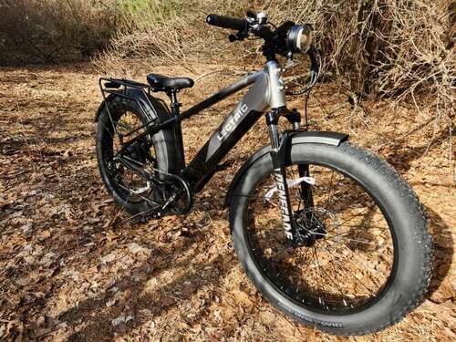 Lectric XPeak right front three-quarter view parked on a forest path.