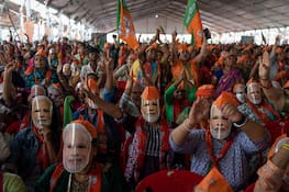 ARCHIV - 31.03.2024, Indien, Meerut: Anhänger des indischen Premierministers Narendra Modi tragen während einer Wahlkampfveranstaltung Masken des Politikers und schwenken Flaggen seiner Bharatiya Janata Party (BJP). (zu dpa: «Größte Wahl der Welt: Wie Premier Modi Indien zum Hindu-Staat umbaut») Foto: Altaf Qadri/AP/dpa +++ dpa-Bildfunk +++