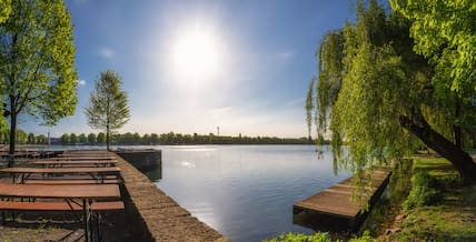 Blick vom Ufer auf den Maschsee, die Sonnenstrahlen erleuchten das Wasser.