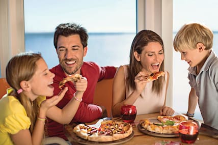 Eine vierköpfige Familie mit Mutterm Vater und zwei Kindern isst auf einem Costa Kreuzfahrtschiff Pizza