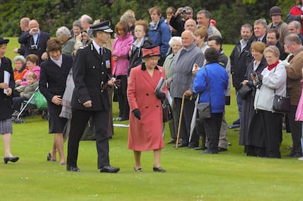 Königin Elizabeth II geht über eine Wiese an Schloss Balmoral.