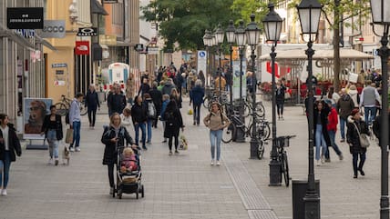 Passanten sind in der Münchner Fußgängerzone unterwegs.