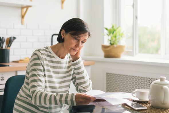 Senior woman looking stressed at letter