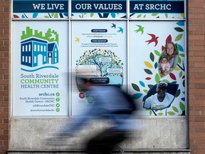 A cyclist passes by the South Riverdale Community Health Centre.