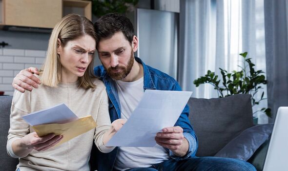 Couple looking shocked at bills