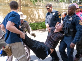 A student protester being carried off by poilice.