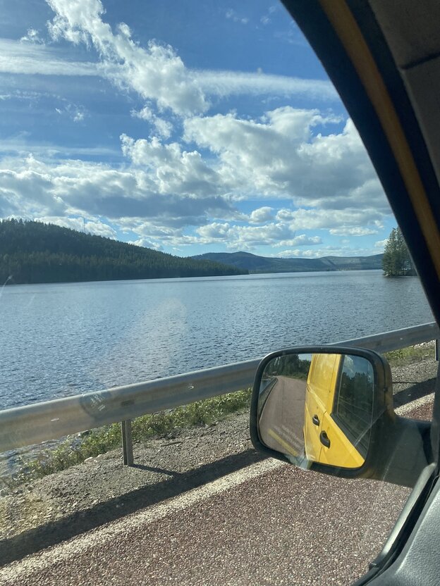 Blick aus einem Autofenster auf eine sommerliche Seenlandschaft