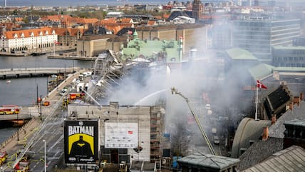 Einsatzkräfte der Feuerwehr arbeiten am Brandort. Ein Feuer hat eines der ältesten Gebäude Kopenhagens schwer beschädigt und den ikonischen Drachenschwanzturm der Alten Börse (Boersen) zum Einsturz gebracht.