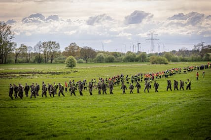 Soldaten der Bundeswehr und Einsatzkräfte der Feuerwehr stellen sich auf, um ein Feld in Gräpel, Niedersachsen, abzusuchen. Der sechs Jahre alte Arian aus Elm wird weiter vermisst.