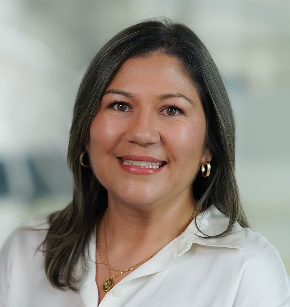 A photo of smiling woman  in a white shirt.