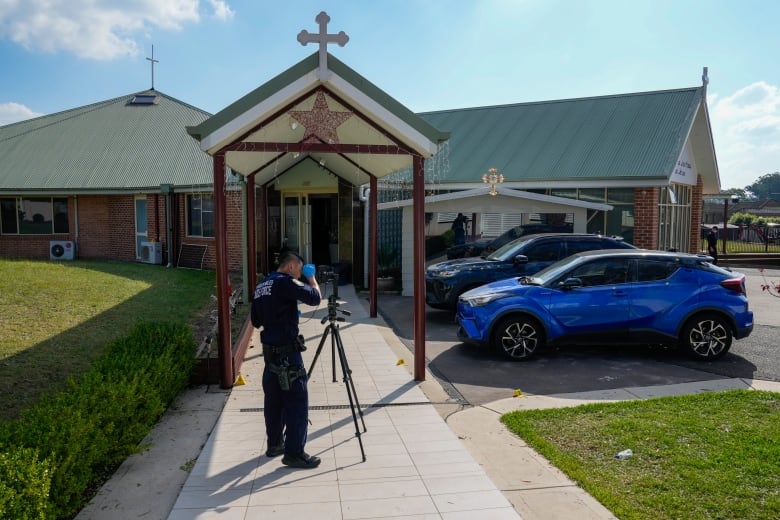 A police officer with a tripod is shown on the sidewalk leading to a small church building.