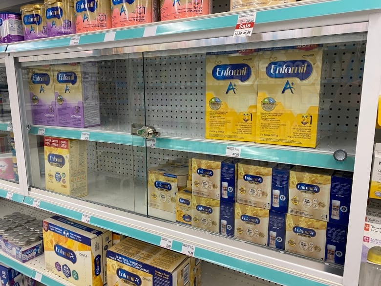 baby formula on a shelf behind glass.