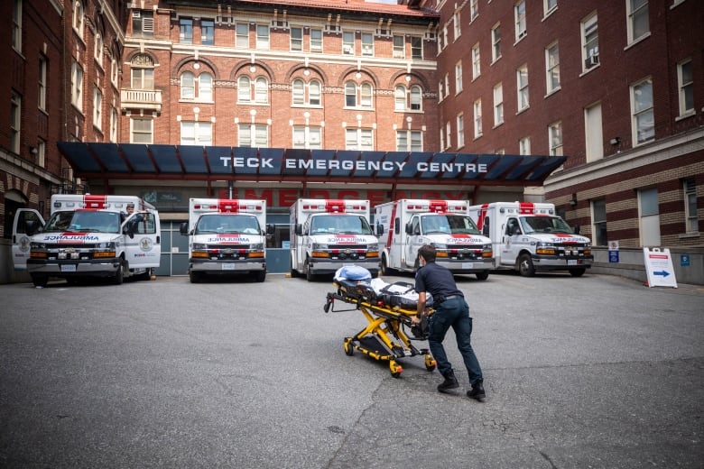 A paramedic rushes a gurney into a hospital.