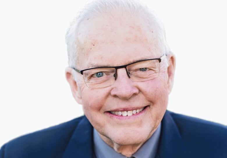 A photo of Bill VanGorder in navy blue suit with a blue shirt and necktie, smiling to the camera. 