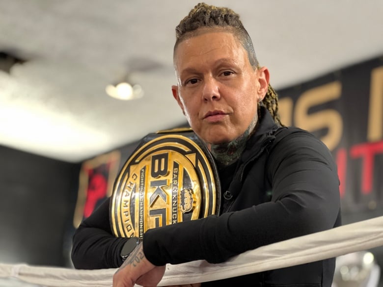 A woman with a large metal belt slung over her shoulder