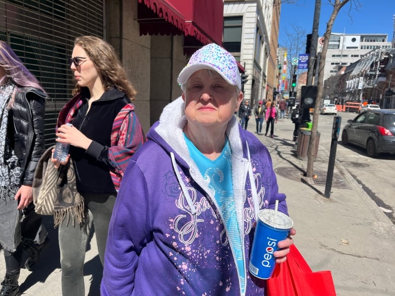 A woman on a downtown street wearing a sequined ball cap