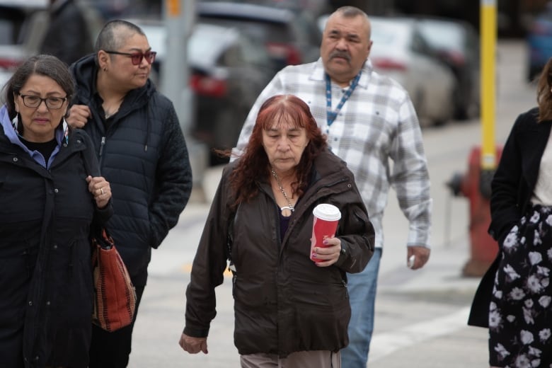 A group of people walk outside.