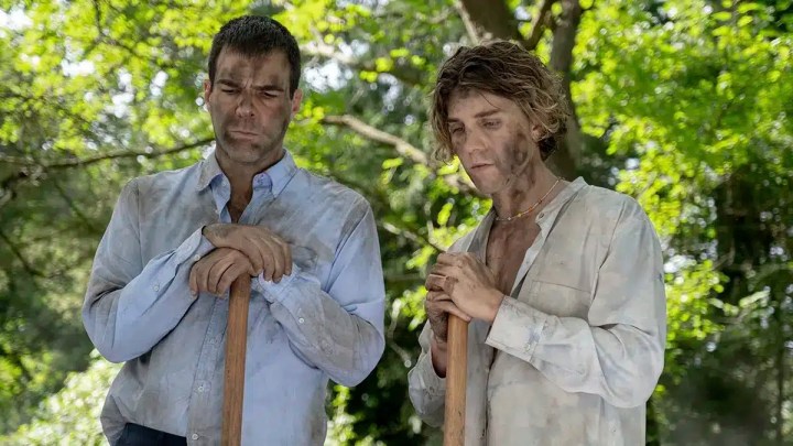 Two men stand with shovels in Down Low.