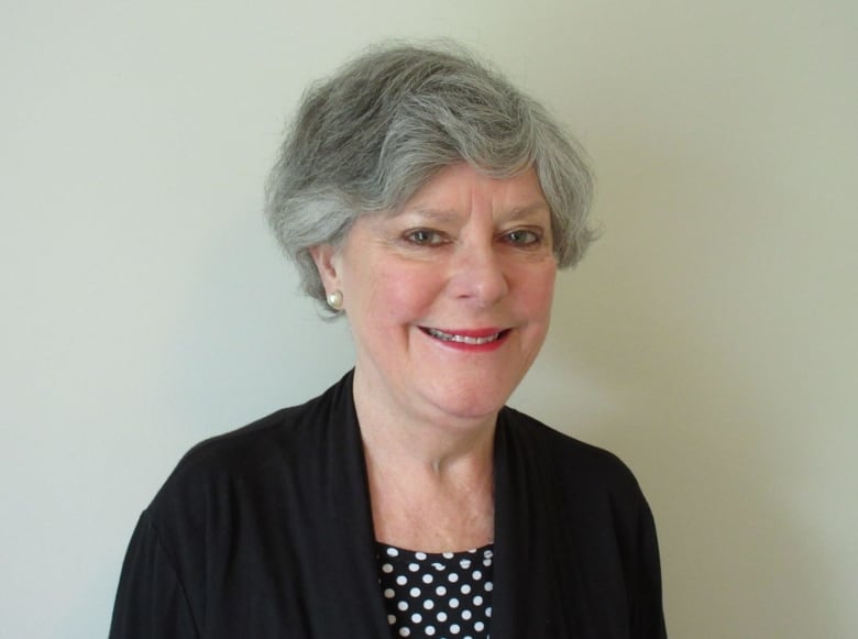 Woman with short grey hair smiling.